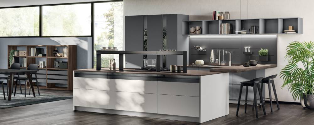 Sofistike aynalı cam ekler. Ada ve Heron Grey ve Volcano Grey mat lake kapılarla kompozisyon; Garden Walnut yapısına sahip “Fluida” Duvar Sistemi ve Volcano Grey mat lake "Assist" çekmeceler.